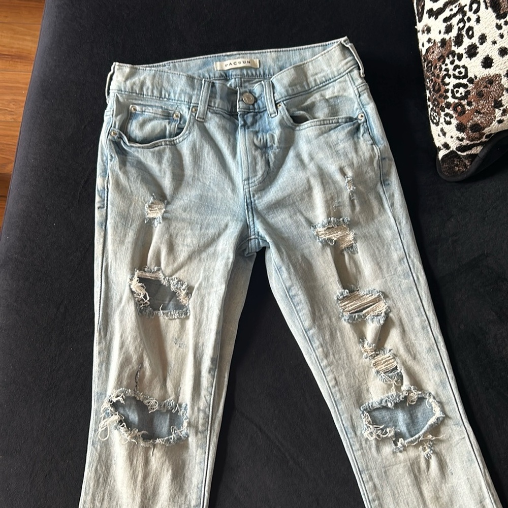 Young men’s light colored distressed denim jeans from Pacsun.